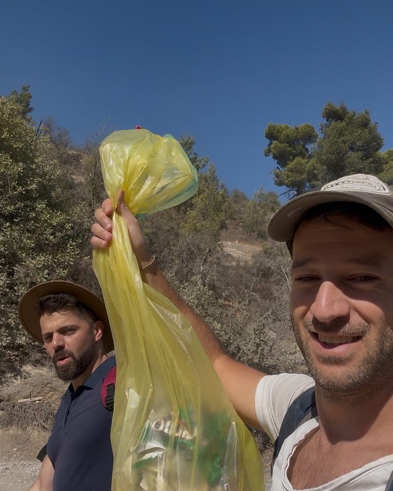 שבי וחבר בשביל עם שקית זבל צהובה מלאה