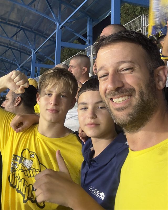 שבי עם שני אוהדים צעירים ביציע של עירוני אשדוד
